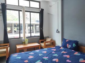 1 dormitorio con cama y ventana grande en Hotel Norbuling en Dirāng