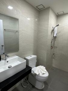 La salle de bains est pourvue d'un lavabo, de toilettes et d'un miroir. dans l'établissement Aston Residence Hatyai, 