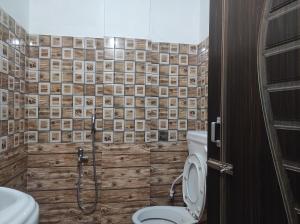 ein Bad mit einem WC und einer Dusche in der Unterkunft Hotel Norbuling in Dirang Dzong