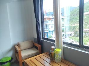 Zimmer mit einem Tisch, einem Stuhl und einem Fenster in der Unterkunft Hotel Norbuling in Dirang Dzong