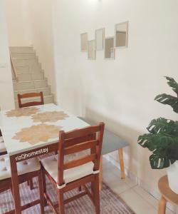 a dining room with a table and chairs and stairs at RizQ Homestay Tg Malim in Kerling