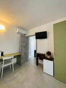 a living room with a desk and a television on the wall at La Ringhiera in Novara