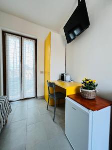 um quarto com uma secretária e uma mesa com uma televisão em La Ringhiera em Novara