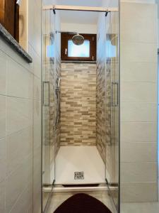 a shower with a glass door in a bathroom at La Ringhiera in Novara