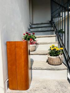 dos cestas de flores sentadas en una escalera en La Ringhiera, en Novara