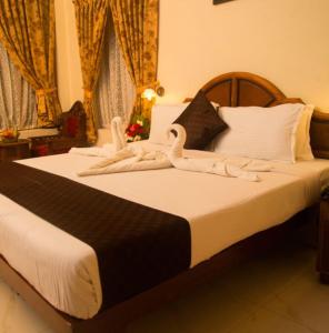 two swans are sitting on top of a bed at Hawah Beach Resort Kovalom in Kovalam