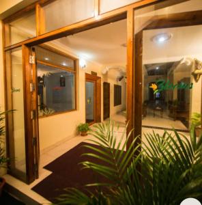 a building with glass doors and a plant in front of it at Hawah Beach Resort Kovalom in Kovalam
