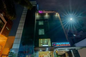een hoog gebouw met lichten erop bij Townhouse Oak JVH hotel (Next to Mysore Road Metro Station) in Bangalore
