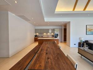 a large wooden table in a living room with a kitchen at Private pool villa 3 Bed, 3 Bath near airport in Phuket