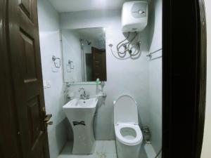 a small bathroom with a toilet and a sink at Himalaya Villa's in Murree