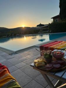 a table with a plate of food next to a swimming pool at Villa Del Sole in San Gimignano