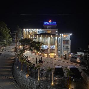 a building with a sign on top of it at night at Hotel Smarak in Heṭauḍā