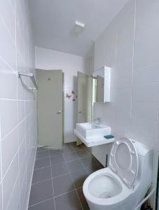 Baño blanco con aseo y lavamanos en NEW Comfy 2BR Suites @ KLCC View / Wi-Fi / MRT en Kuala Lumpur