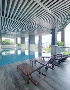 una piscina con dos mesas y un banco en un edificio en NEW Comfy 2BR Suites @ KLCC View / Wi-Fi / MRT en Kuala Lumpur