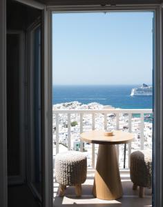 a table and chairs on a balcony with a view of the ocean at Νumi Boutique Hotel in Mýkonos City