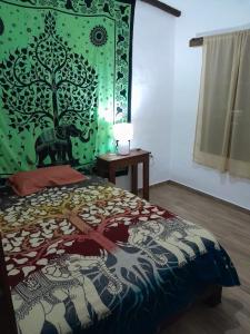 ein Schlafzimmer mit einem Bett und einer grünen Wand in der Unterkunft CABAÑAS DOS RIOS in Cotacachi