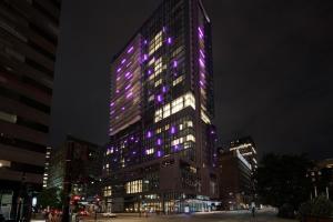a tall building with purple lights on it at HONEYROSE Hotel, Montreal, a Tribute Portfolio Hotel in Montreal
