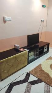 a living room with a couch and a flat screen tv at Siti Homestay in Pasir Mas
