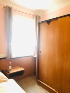 a bedroom with a large window and a wooden door at Holmes Café & Pension in Engelhartszell +32 photos