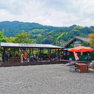 a building with tables and umbrellas in front of it at SLEEPY MOUNTAIN in Karatsu