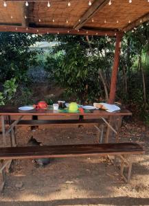 a wooden picnic table under a wooden roof at Agriturismo val martina in Scarlino