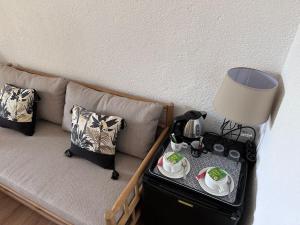 a couch with a table with a lamp on it at Hôtel Résidence Le Phoenix in Saint-Pierre