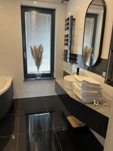 a bathroom with two sinks and a mirror and a window at Chojno 31- dom wypoczynkowy przy jeziorze z jacuzzi in Chrostkowo