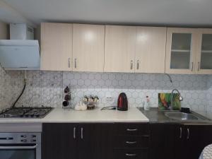 a kitchen with a sink and a stove and cabinets at apartament ultra centru in Chişinău +3 photos
