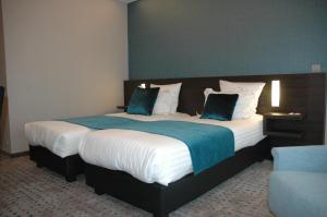 a bedroom with a large bed with blue and white sheets at Hotel Restaurant Weinebrugge in Bruges