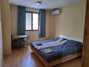 a bedroom with a bed and a table and a window at Berek Vendégház Fonyód in Fonyód