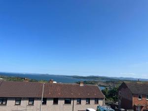 a view of a body of water behind some buildings at Bright, comfy and peaceful house in Inverkeithing