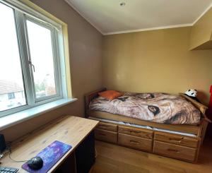 a bedroom with a bed with a desk and a window at Bright, comfy and peaceful house in Inverkeithing