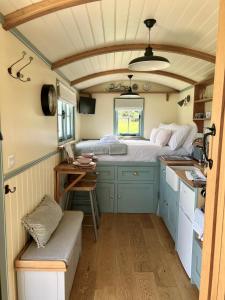 a small room with a bed and a table at Toms Hut and Robins Rest Shepherd Huts near Wadebridge in Wadebridge