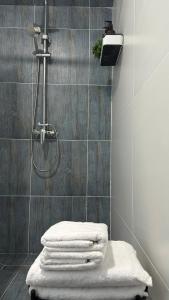 a bathroom with a shower with towels on a stool at BAYHOUSE - Уютные апартаменты в микрорайоне Жетысу 4 in Imeni Stalina