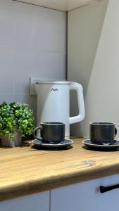 two cups on a counter with a coffee maker at BAYHOUSE - Уютные апартаменты в микрорайоне Жетысу 4 in Imeni Stalina