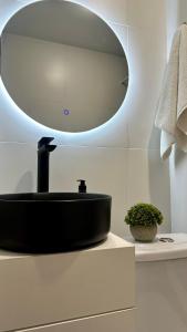 a bathroom with a black sink and a mirror at BAYHOUSE - Уютные апартаменты в микрорайоне Жетысу 4 in Imeni Stalina