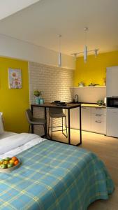 a bedroom with a bed and a kitchen with a table at BAYHOUSE - Уютные апартаменты в микрорайоне Жетысу 4 in Imeni Stalina