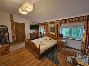 1 dormitorio con 1 cama, TV y mesa en Hotel Villa Hubertus Kutno, en Kutno