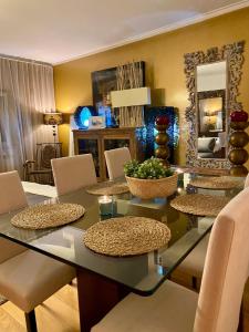 comedor con mesa de cristal y sillas en Luxury Family suite for 4, en Caxias