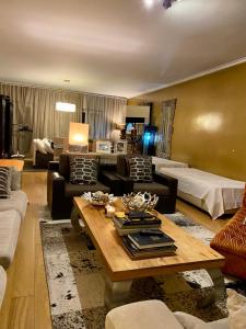 uma sala de estar com um sofá e uma mesa em Luxury Family suite for 4 em Caxias