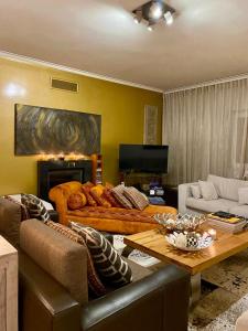 uma sala de estar com um sofá e uma mesa em Luxury Family suite for 4 em Caxias
