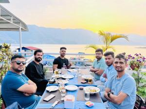 a group of men sitting at a table eating food at Hotel Kunja in Pokhara