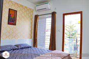 1 dormitorio con cama y ventana grande en StayMazing Boutique AC Apartments-Manyata,Hebbal-1,2&3 BHKs-30mins to Airport, en Bangalore