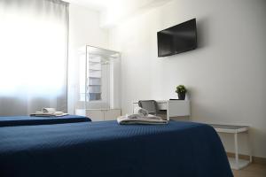 1 dormitorio con 2 camas y TV en la pared en Dino's Rooms, en Lioni