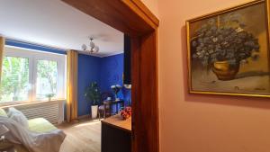 a room with a painting of a vase of flowers on the wall at Apartament Kraszewskiego - Retro, blisko Starówki, koło parku, ogród dla gości, rowery free in Toruń +24 photos