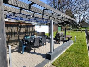 a patio with a table and chairs under a pergola at Ferienhaus Linda in Wanna