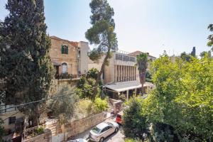 eine Straße mit Autos, die vor einem Gebäude geparkt sind in der Unterkunft Hovevey Tsiyon Luxury Apartment By Nimizz in Jerusalem