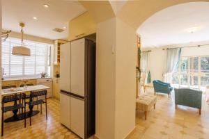 a kitchen with a refrigerator and a table with chairs at Hovevey Tsiyon Luxury Apartment By Nimizz in Jerusalem