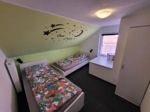 a bedroom with two beds and a wall with a moon and stars at Ferienhaus Linda in Wanna