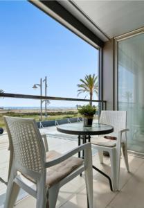 uma mesa e cadeiras numa varanda com vista para o oceano em 1ª LÍNEA DE PLAYA. Apartamento: LA CALMA em Comarruga